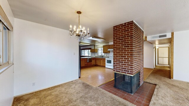 kitchen with pendant lighting, sink, dark carpet, and electric range