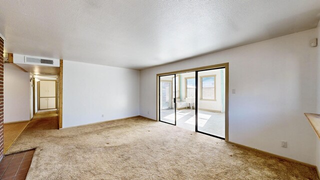 carpeted spare room featuring a textured ceiling