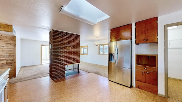 kitchen with a brick fireplace, light carpet, pendant lighting, and stainless steel fridge with ice dispenser