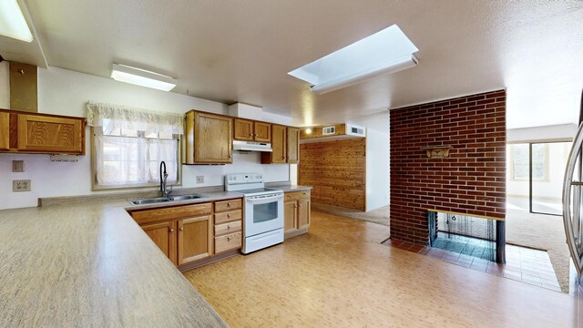 kitchen with electric stove, sink, and a skylight