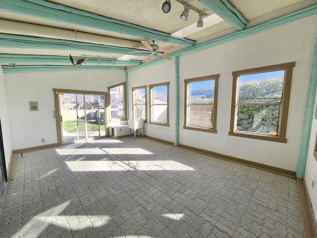 unfurnished sunroom featuring beamed ceiling, track lighting, and ceiling fan