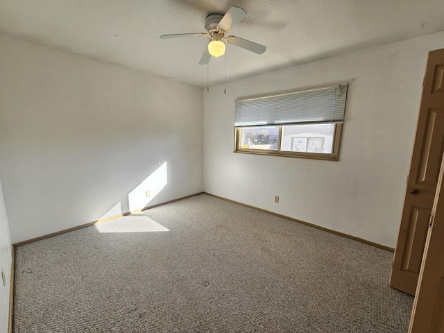 empty room featuring ceiling fan and carpet