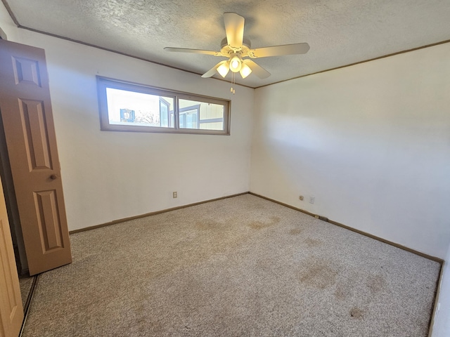 unfurnished room featuring ceiling fan, light colored carpet, ornamental molding, and a textured ceiling