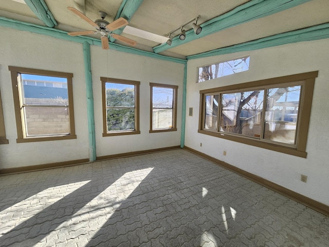 unfurnished room featuring track lighting and ceiling fan