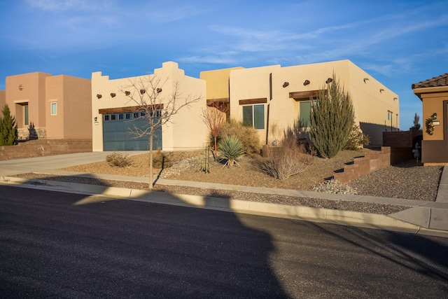 pueblo-style home with a garage