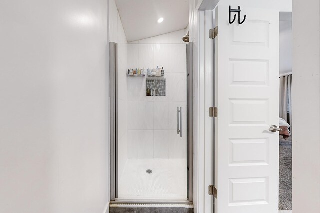 bathroom with vaulted ceiling and a shower with door