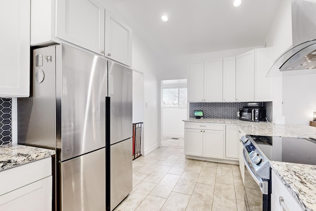 kitchen featuring light tile patterned floors, white cabinetry, appliances with stainless steel finishes, range hood, and light stone counters