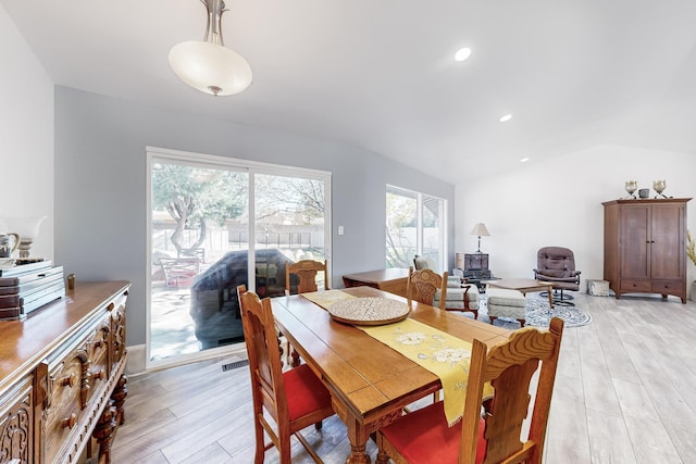 dining room featuring lofted ceiling and light hardwood / wood-style floors