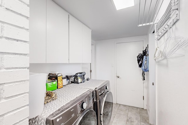 laundry area featuring cabinets, light tile patterned floors, and independent washer and dryer