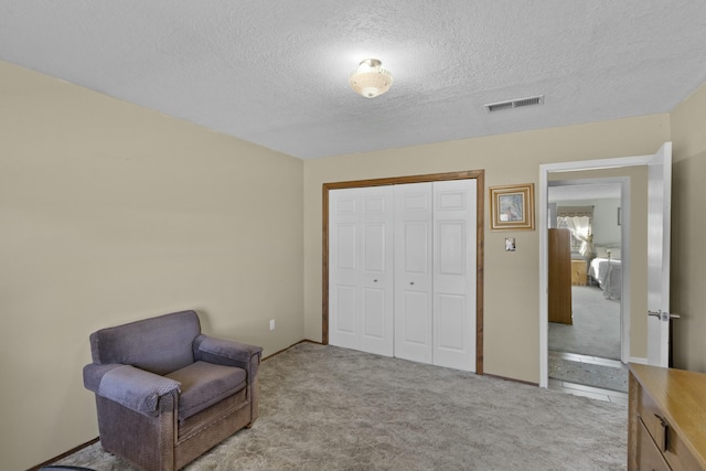 living area with light colored carpet and a textured ceiling