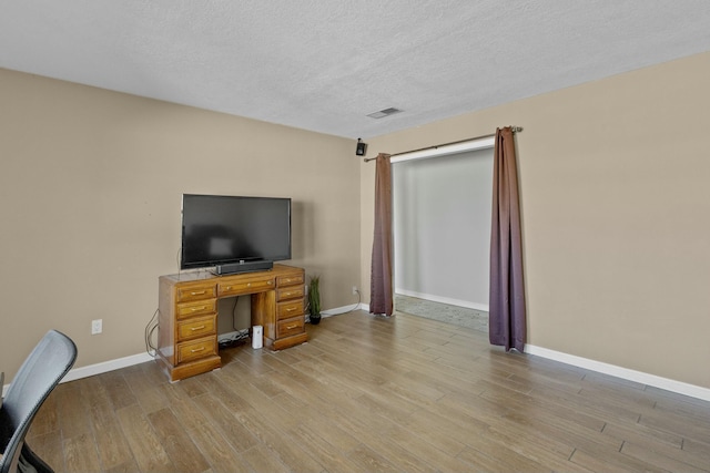 office area with a textured ceiling and light wood-type flooring