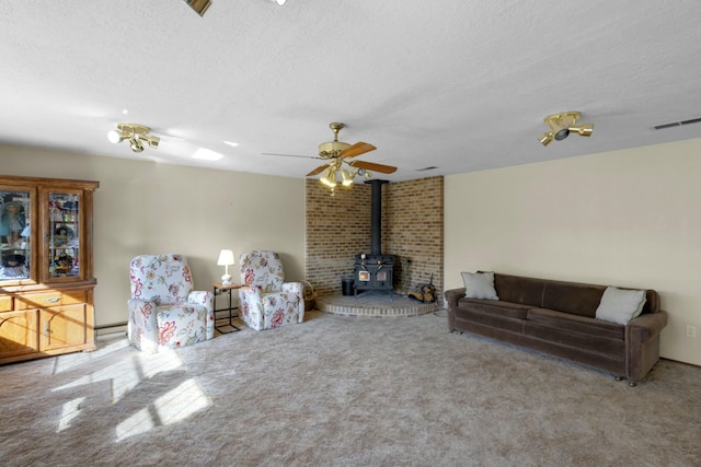 living room with baseboard heating, a textured ceiling, and a wood stove