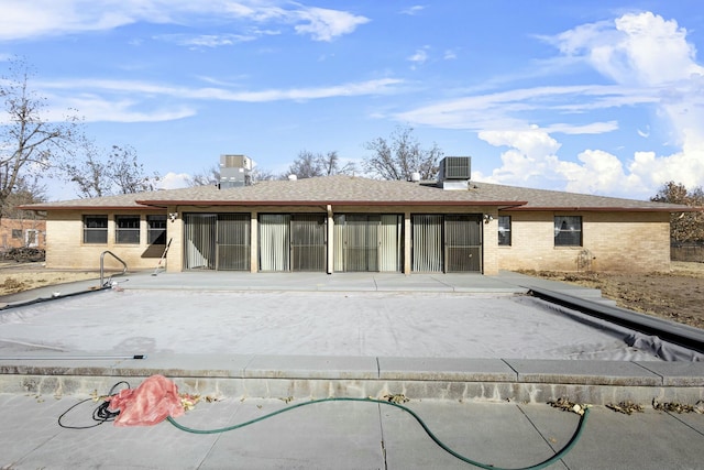 back of property with a patio and central AC