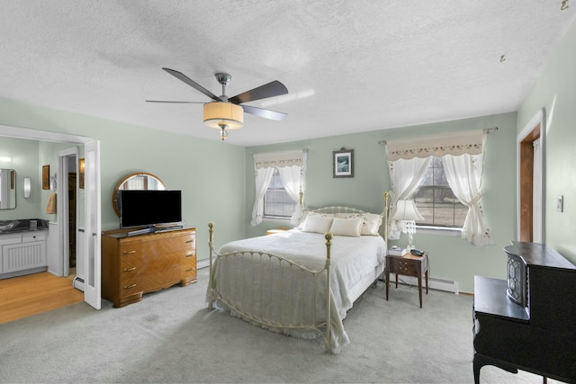 carpeted bedroom with multiple windows, ensuite bath, and a textured ceiling