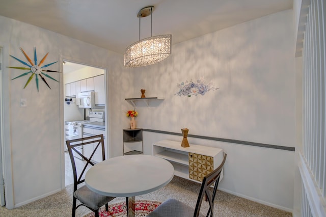 dining area featuring a notable chandelier and light colored carpet