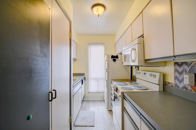 kitchen featuring white cabinets and white appliances