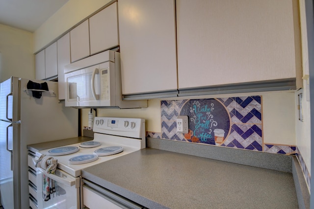 kitchen featuring white cabinetry and white appliances