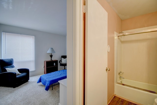 bathroom with hardwood / wood-style floors and shower / washtub combination