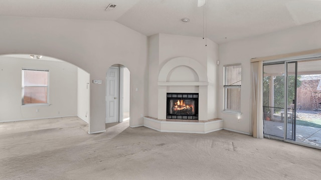 unfurnished living room featuring lofted ceiling and light colored carpet