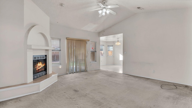 unfurnished living room featuring carpet, vaulted ceiling, a tile fireplace, and ceiling fan