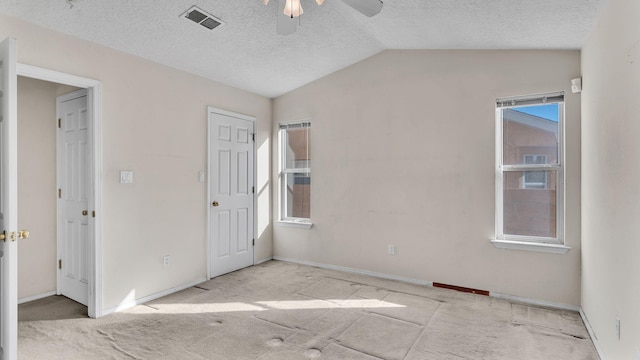 unfurnished bedroom featuring ceiling fan, a textured ceiling, and lofted ceiling