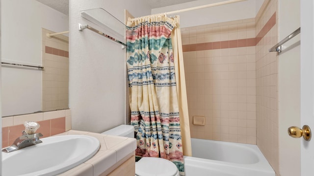 full bathroom with a textured ceiling, toilet, vanity, and shower / bath combo with shower curtain