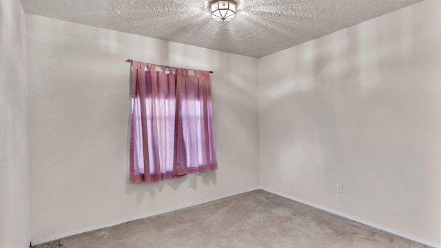 carpeted spare room with a textured ceiling