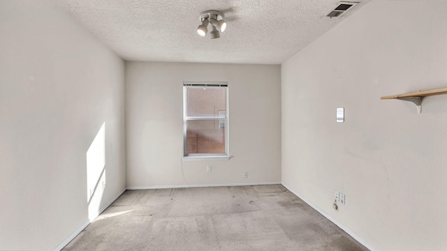 unfurnished room with light carpet and a textured ceiling