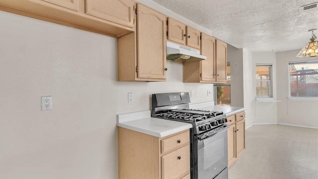 kitchen featuring light brown cabinets, gas range, and a textured ceiling