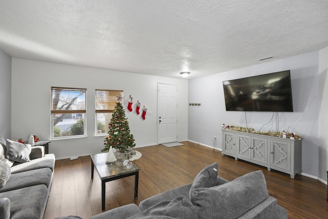 living room with a textured ceiling and dark wood-type flooring