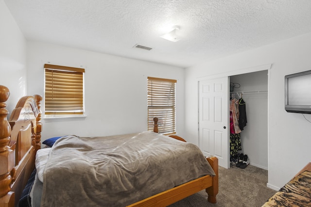 carpeted bedroom featuring a textured ceiling and a closet