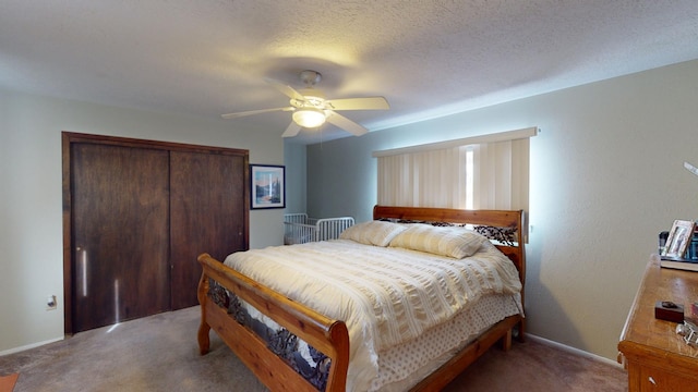 carpeted bedroom with ceiling fan, a textured ceiling, and a closet