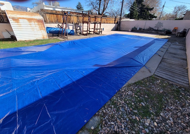 view of swimming pool featuring a storage unit