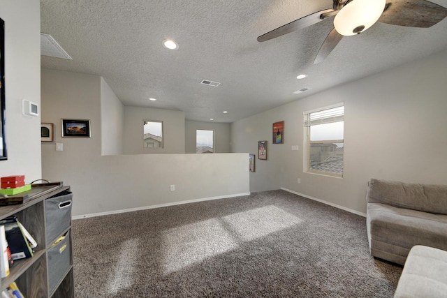 carpeted living room with a textured ceiling and ceiling fan