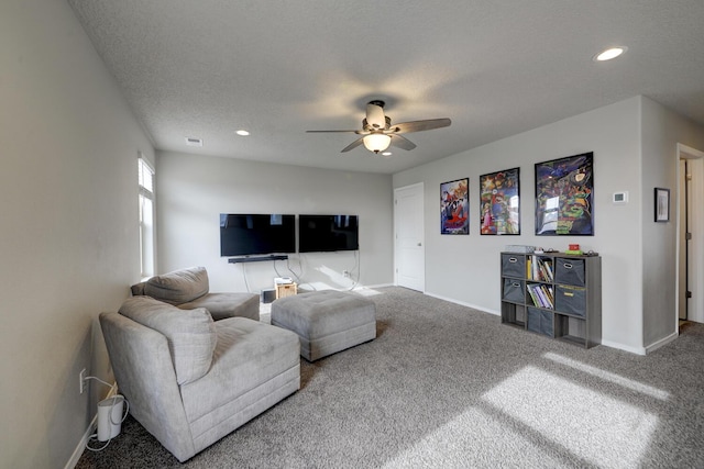 living room featuring carpet flooring, ceiling fan, and a textured ceiling