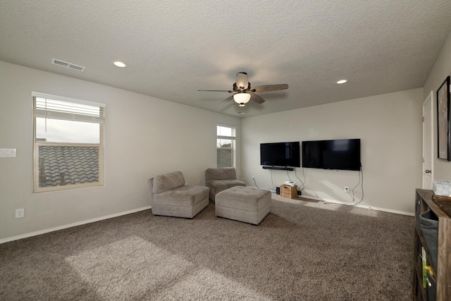 living room with carpet, a textured ceiling, and ceiling fan