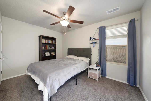 carpeted bedroom with ceiling fan and a textured ceiling