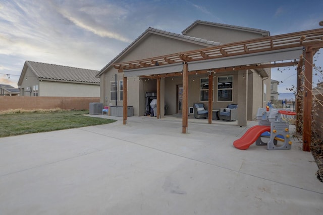 rear view of house with outdoor lounge area, cooling unit, a patio area, and a lawn