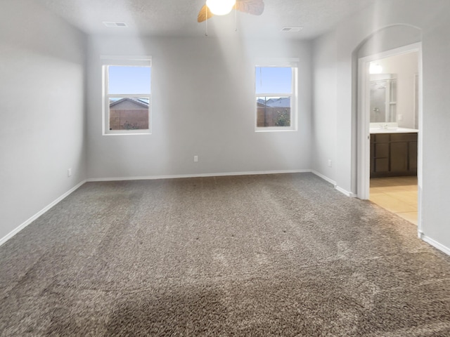 spare room with ceiling fan, light colored carpet, and a textured ceiling