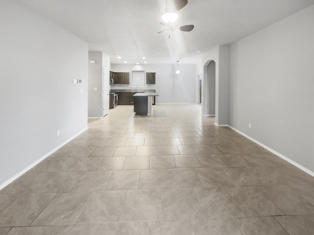 unfurnished living room featuring ceiling fan and light tile patterned flooring