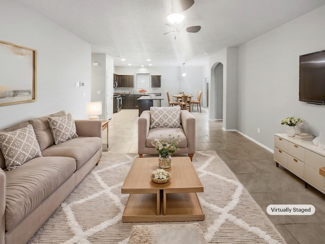 tiled living room with ceiling fan