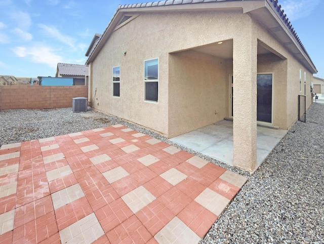 rear view of property with central AC unit and a patio area