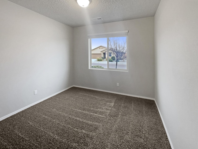 unfurnished room featuring carpet and a textured ceiling