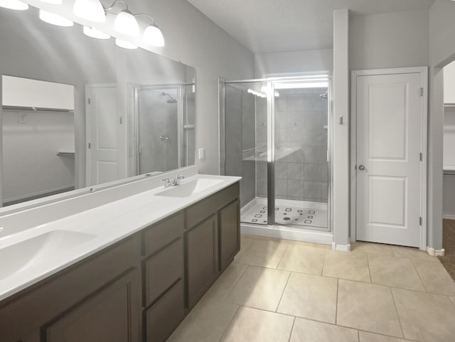 bathroom with tile patterned flooring, vanity, and a shower with shower door