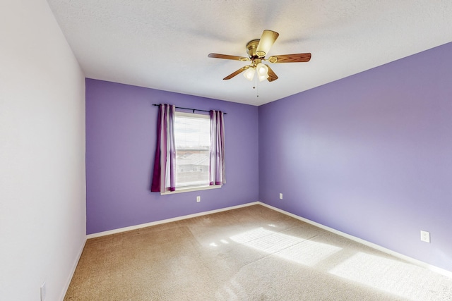 empty room featuring a textured ceiling, carpet floors, and ceiling fan