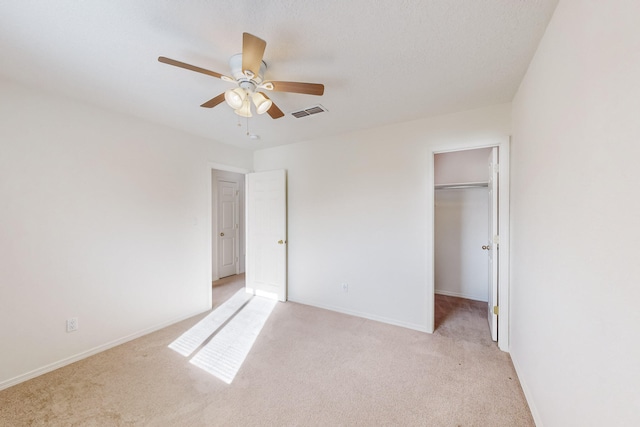 unfurnished bedroom featuring ceiling fan, light colored carpet, and a closet