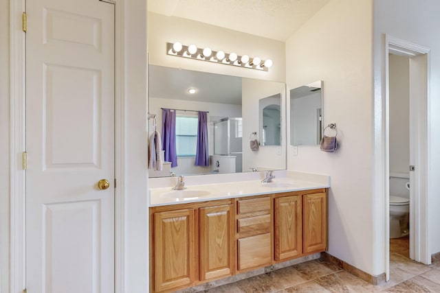 bathroom with a textured ceiling, vanity, toilet, and an enclosed shower