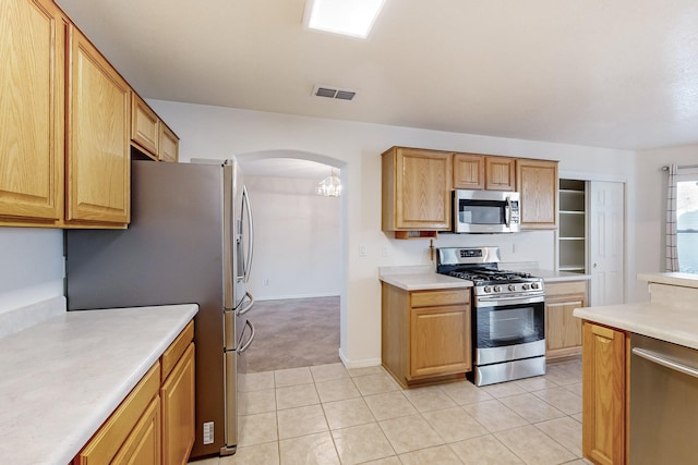 kitchen with light tile patterned floors, stainless steel appliances, and a chandelier