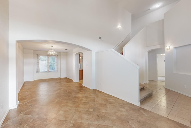 unfurnished room featuring an inviting chandelier and light tile patterned flooring