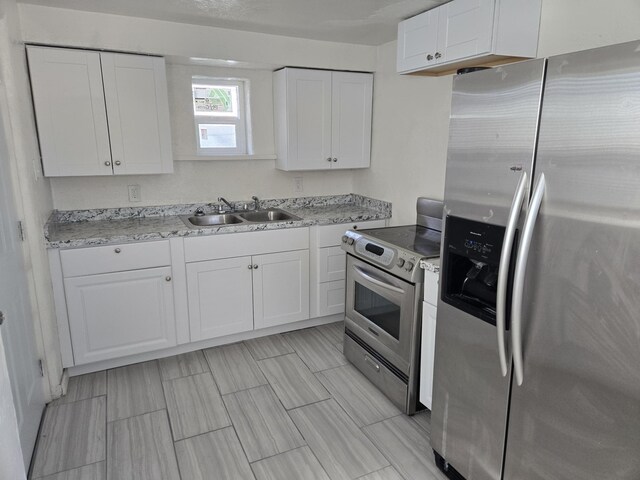 kitchen featuring stainless steel appliances, sink, and white cabinets